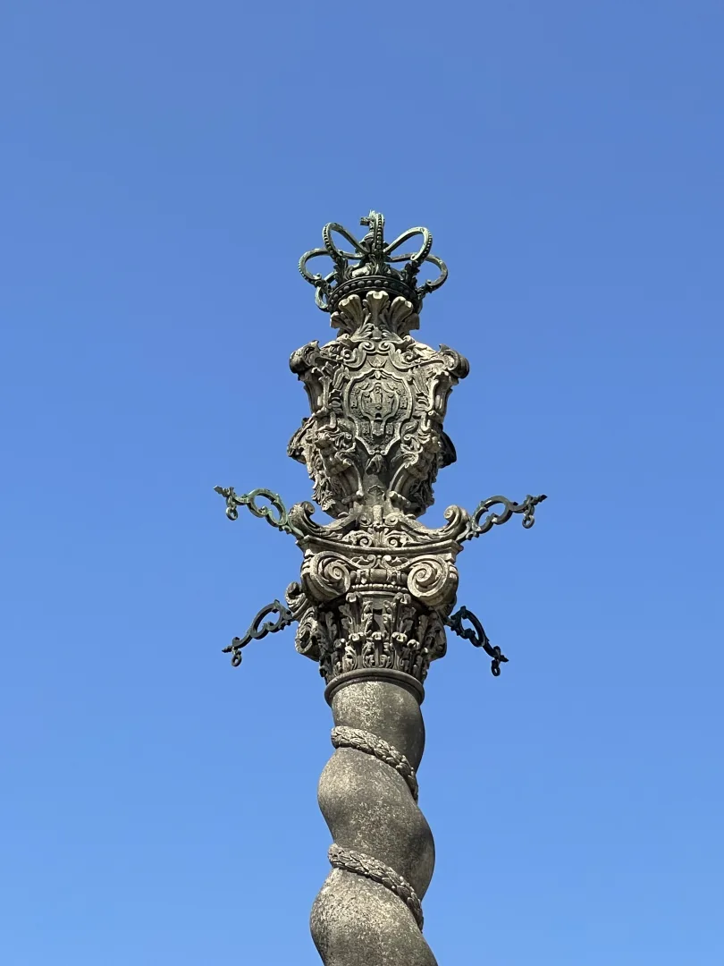 Couronne et blason sculptés au sommet de la colonne torsadée du Pilori de Porto