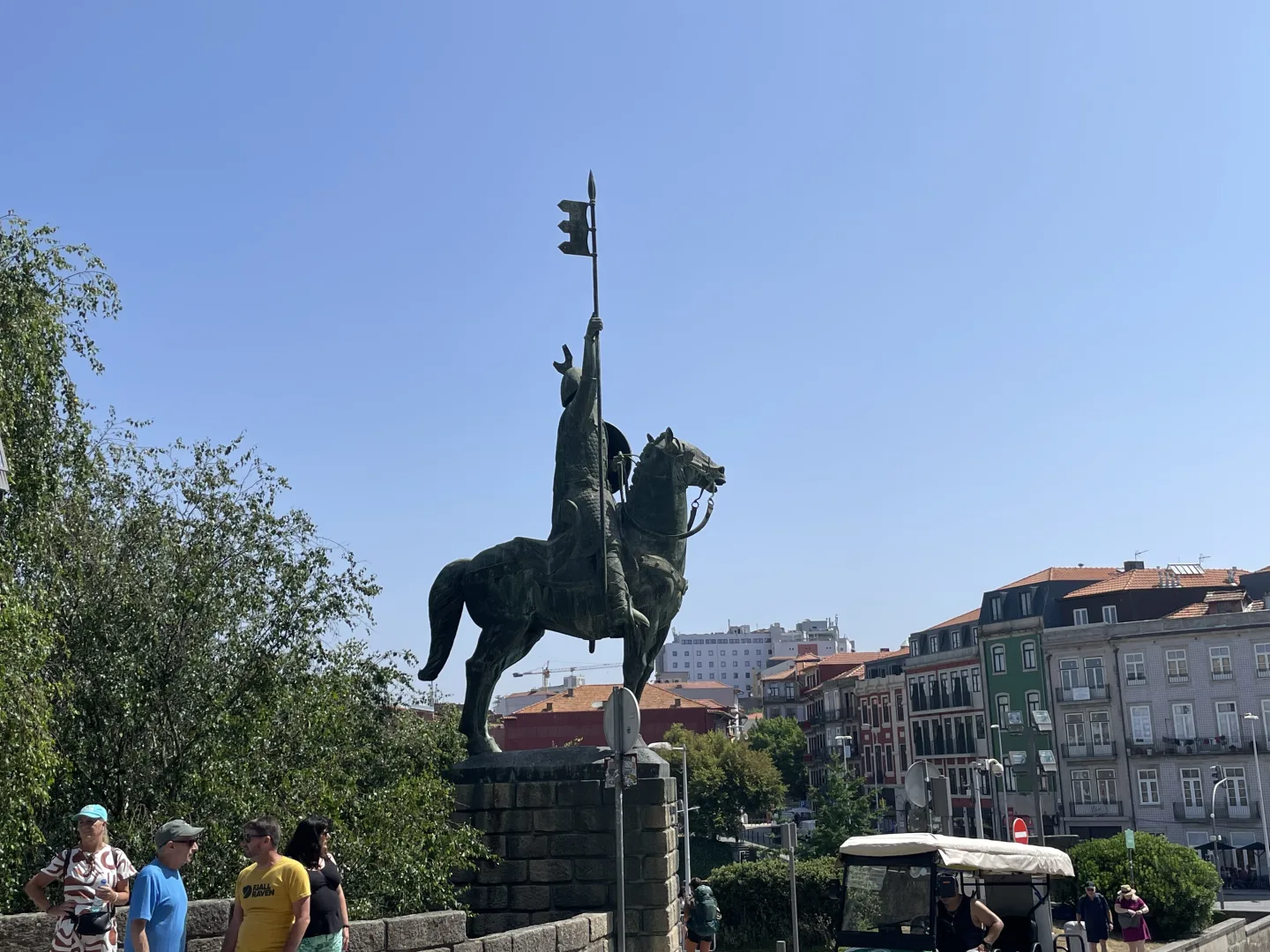 Statue de Vímara Peres vue de dos, dominant les toits de Porto et les bâtiments du centre historique.