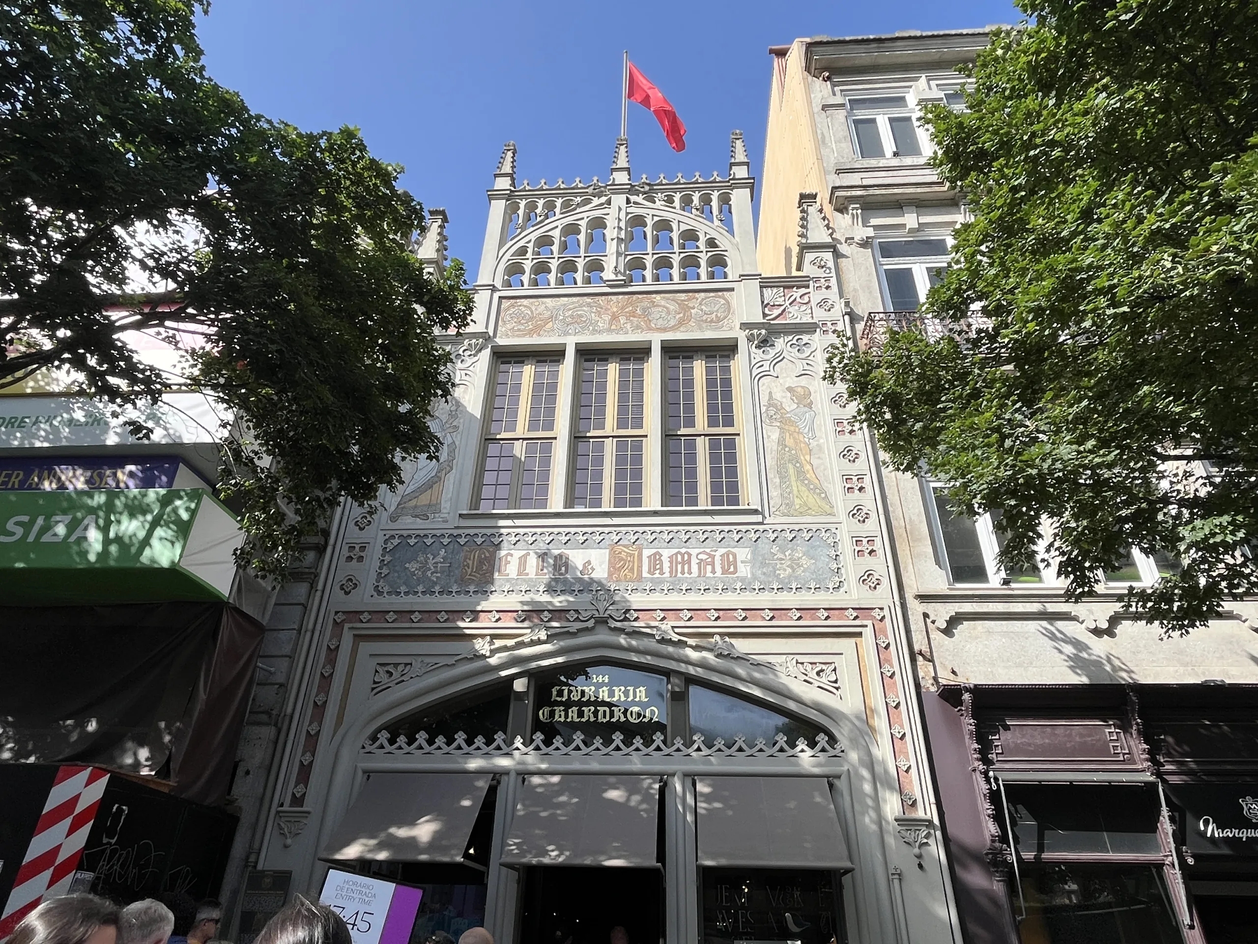 Façade néogothique de la Librairie Lello à Porto avec son drapeau rouge et ses motifs peints